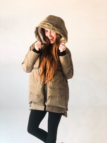 Reviewer wearing the hooded coat in olive green