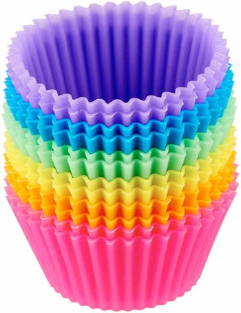 a stack of rainbow colored silicone muffin liners