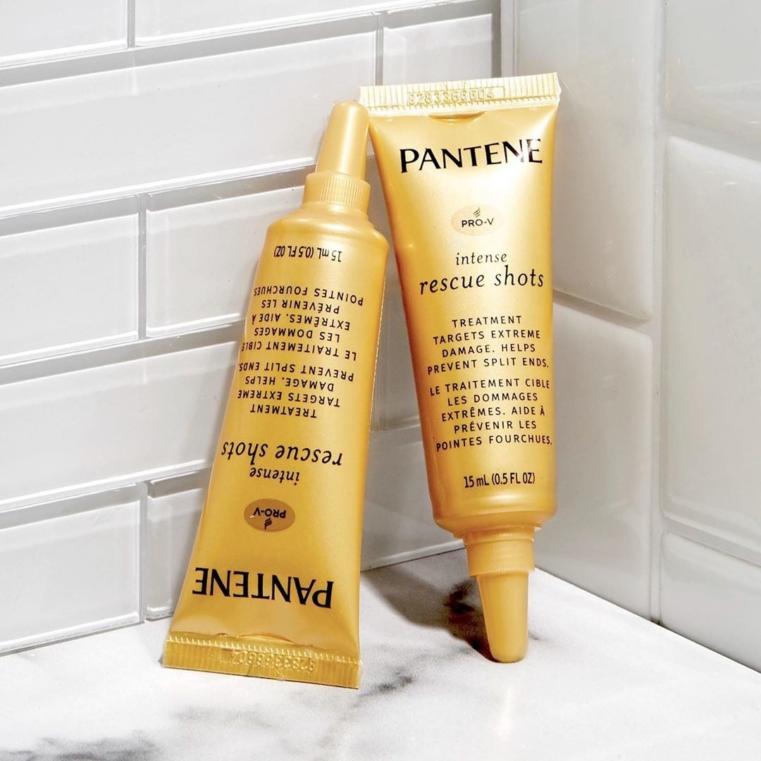 Two Pantene rescue shots leaning against a bathroom wall