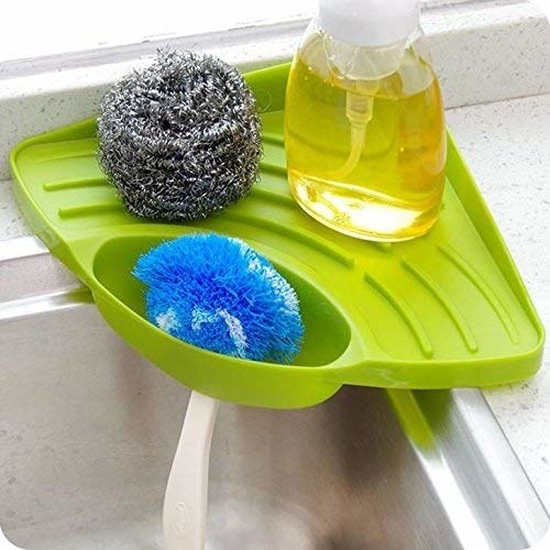 A green sink organiser tray with scrubs and dish wash in it.