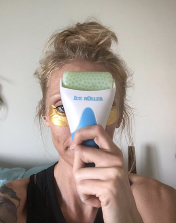 a reviewer rolling the ice roller over their forehead