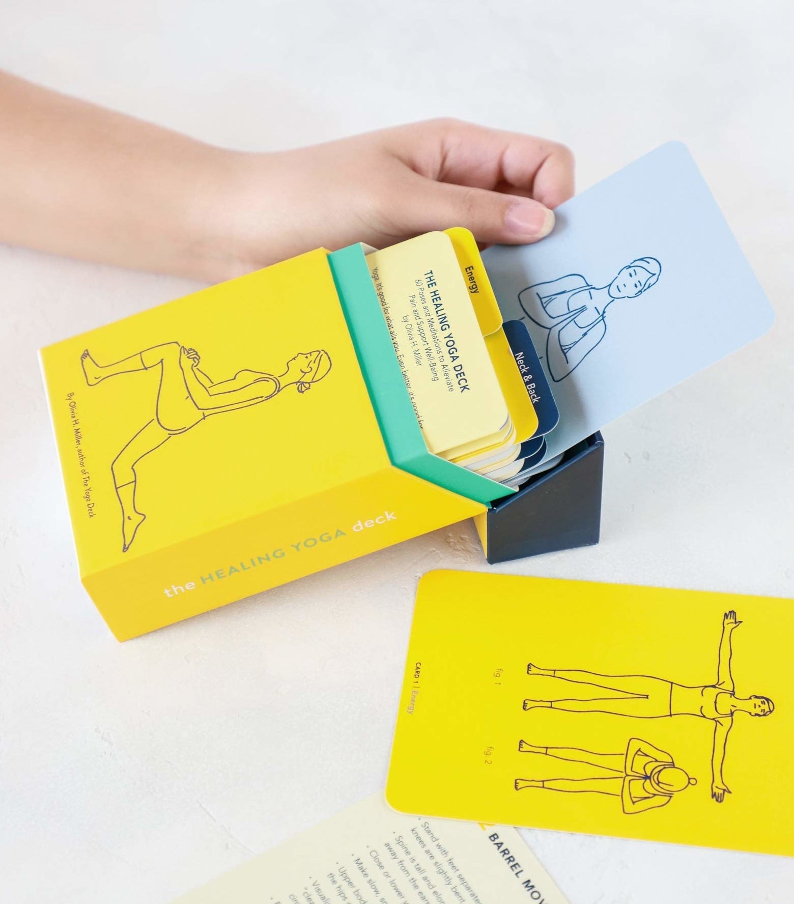 A person pulling a yoga card out of the box