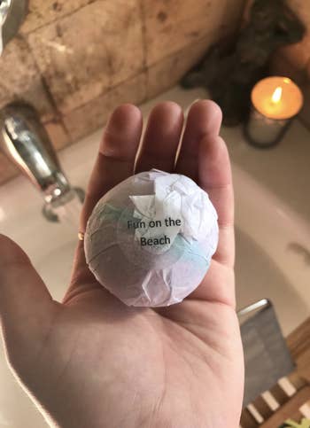 a reviewer holding one of the bath bombs