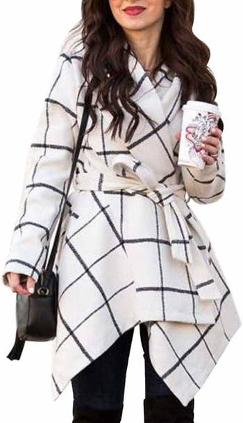 a model in the coat in white with black lines on it