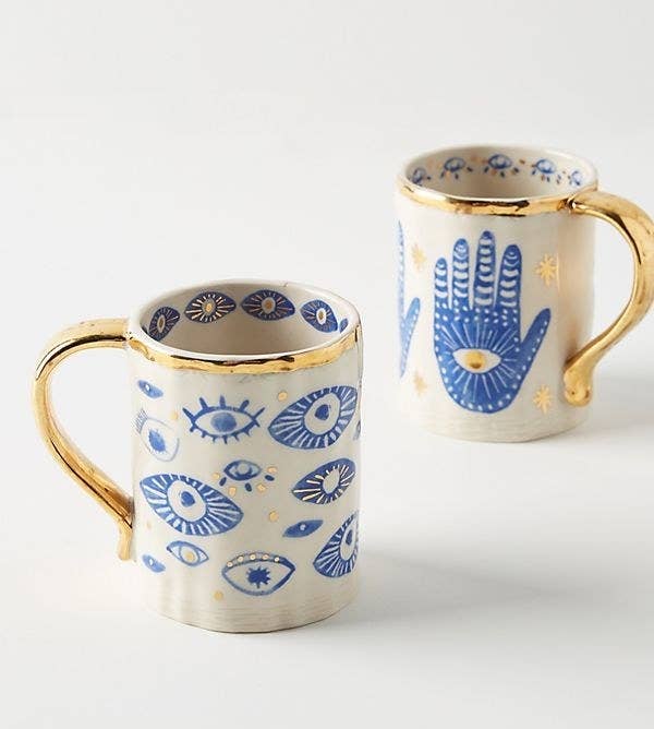 white mugs with blue eye designs and gold handles 