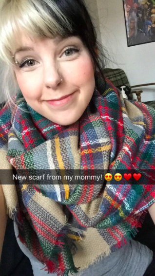 A reviewer wearing the scarf in tan, blue, green, red, and yellow plaid with the caption 