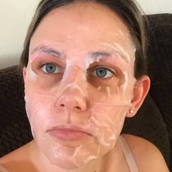reviewer with the removable sheet mask on their face 
