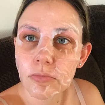 reviewer with the removable sheet mask on their face 
