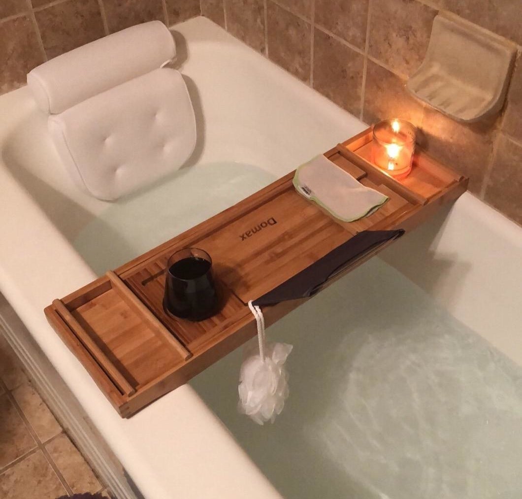 A reviewer&#x27;s bathtub with the white pillow suctioned to the edge