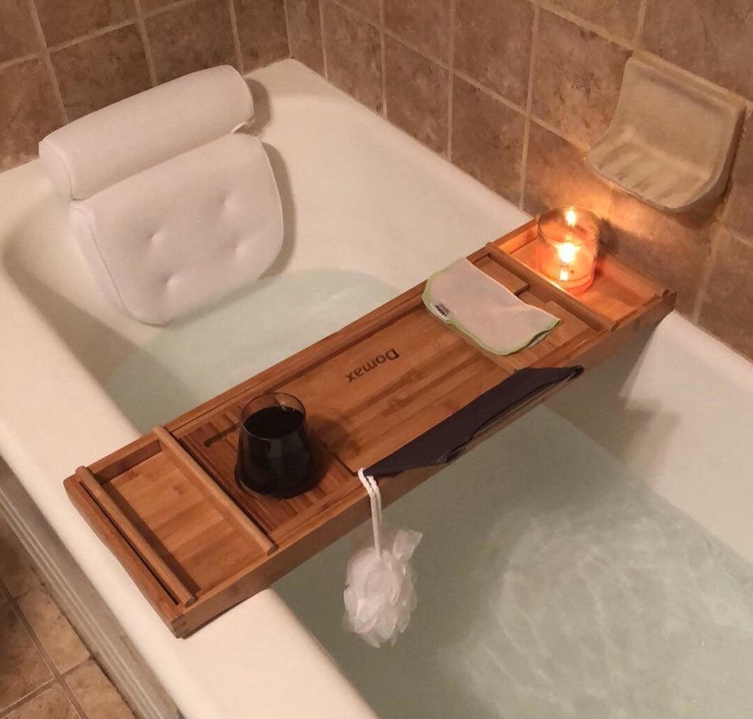 A reviewer&#x27;s bathtub with the white pillow suctioned to the edge