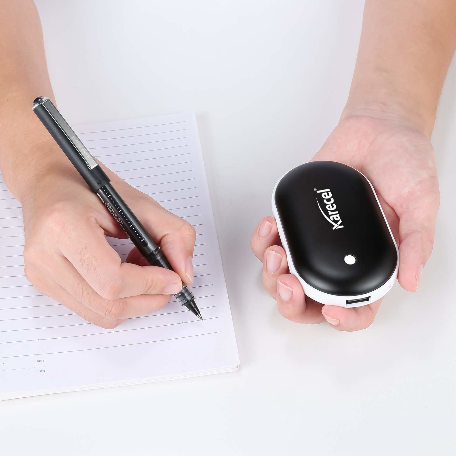 A hand holding the black, computer mouse sized and shape warmer