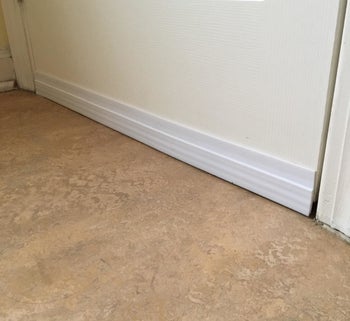 the white draft stopper installed underneath a reviewer's door