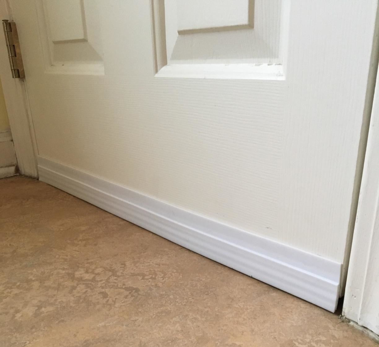 the white draft stopper installed underneath a reviewer's door