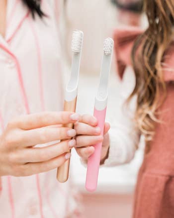 two models holding the toothbrushes in rose gold and pink