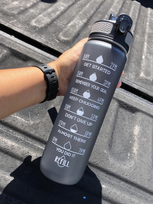 person holding up a hydration tracking bottle