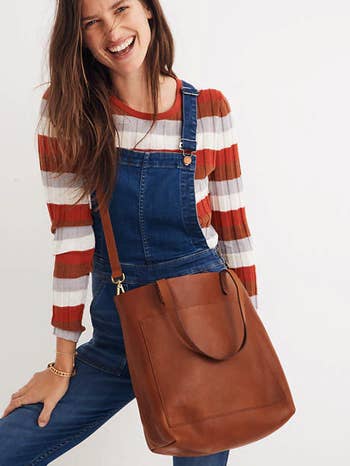 a model wearing the oversized brown tote bag