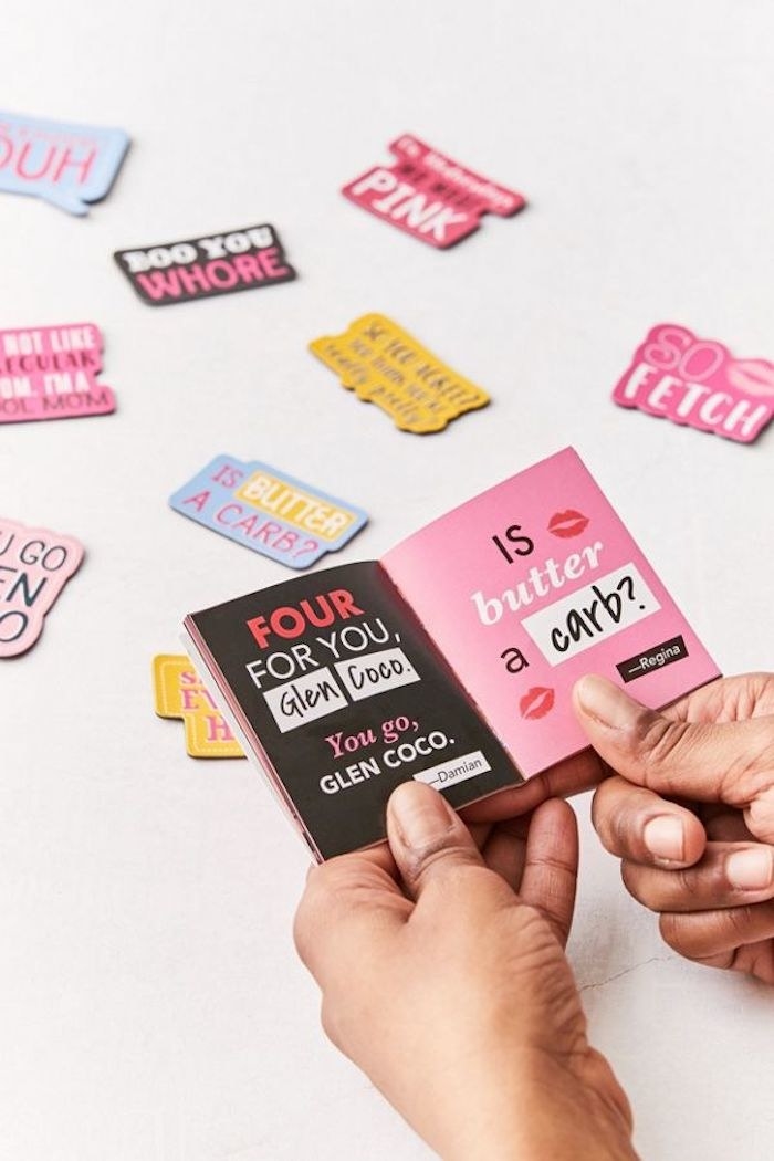 Mean girls magnets with different Mean Girls quotes. A pair of hands is holding the burn book magnet open.