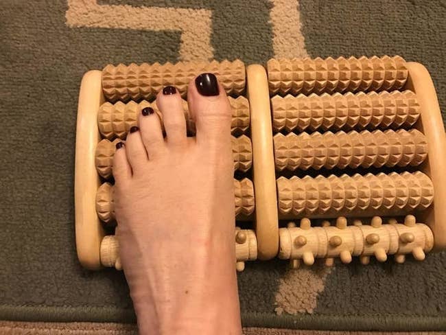 reviewer's foot on the small roller foot massager 