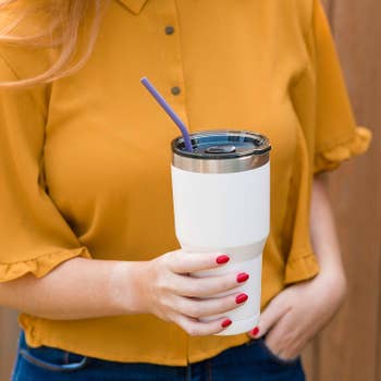 a model holding a cup with a straw in it