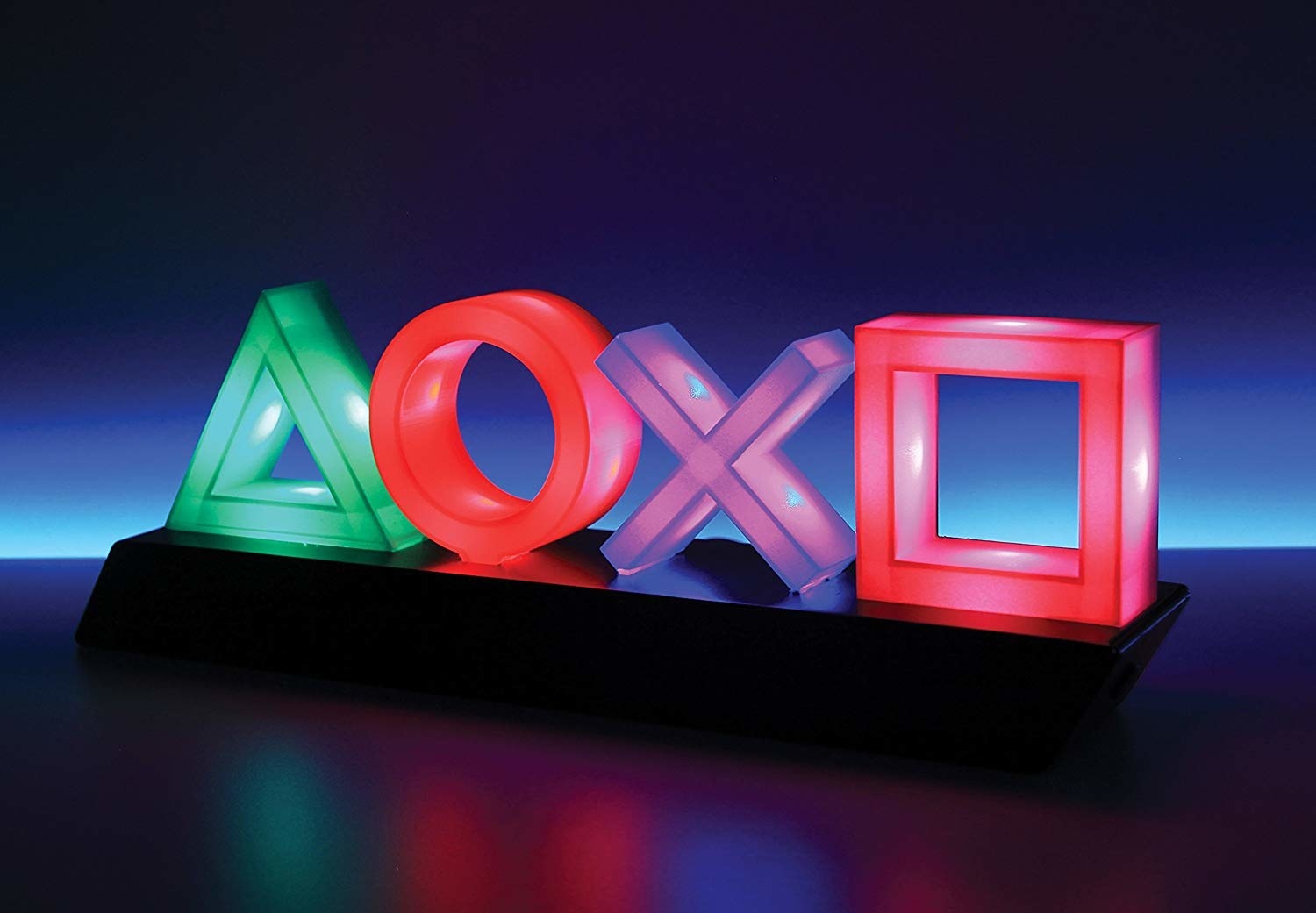 A neon light of the Playstation symbols arranged on a dark surface