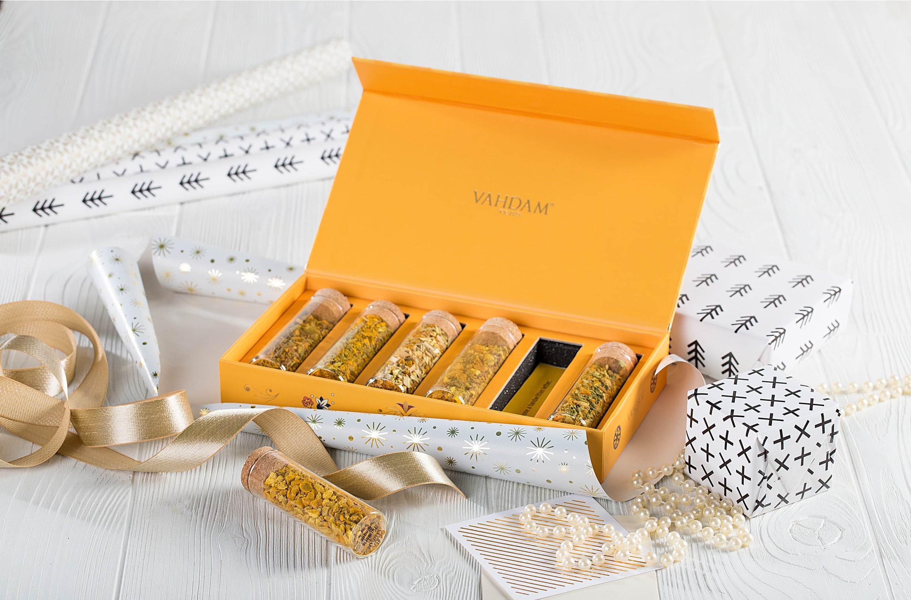 The rectangle-shaped yellow box with six tubes of loose-leaf tea inside