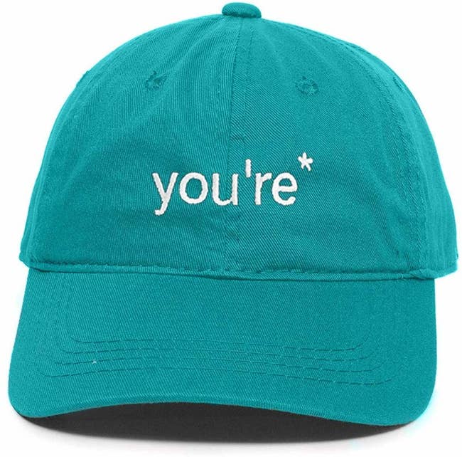Teal baseball cap with white text that reads 