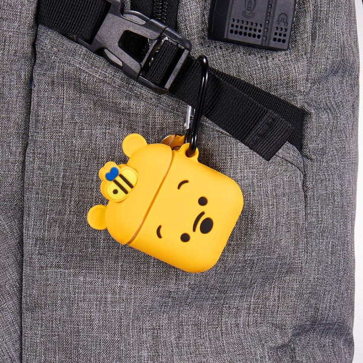 the winnie the pood airpod case attached to a backpack