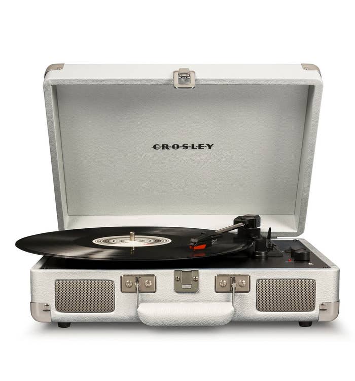 The square-shaped turntable in silver open to show the black inside with a record in it