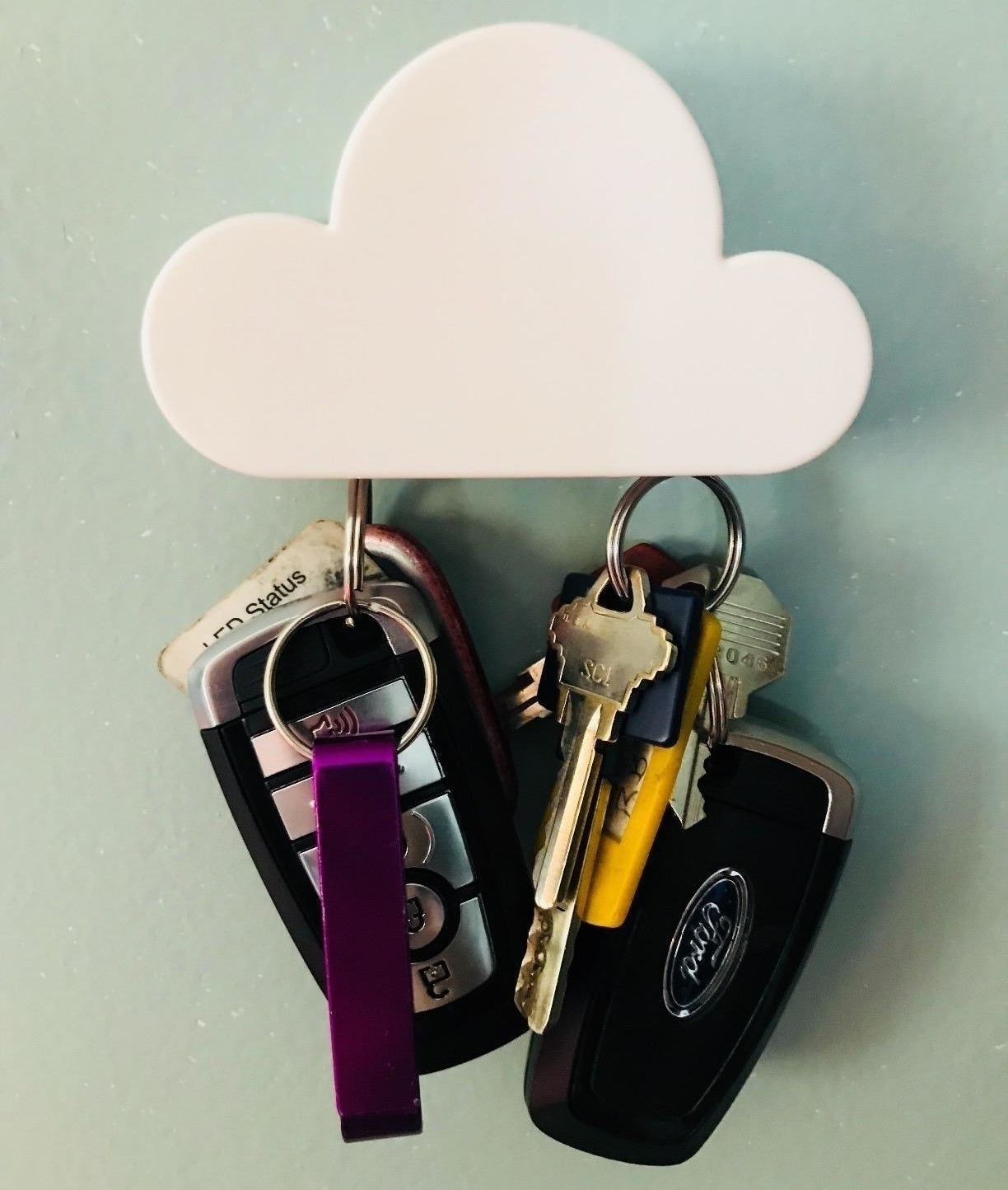 Two pairs of keys suspended by the cloud-shaped magnetic key holder  