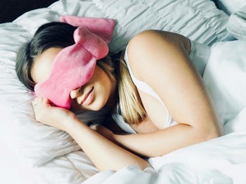 model wearing the pink sleep mask in bed