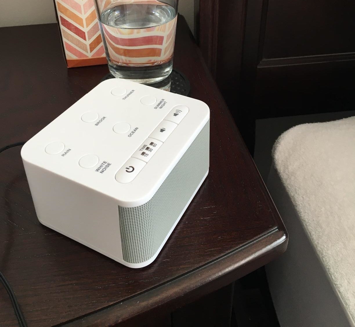 the white rectangular noise machine on a night stand
