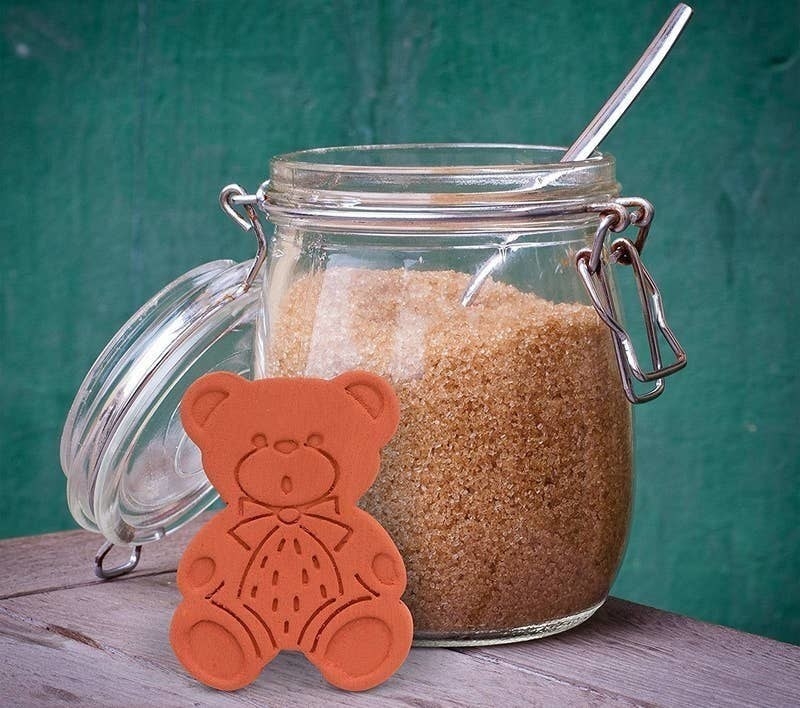 The brown sugar bear outside of a jar of brown sugar