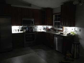 Kitchen cabinets in a dark room with bright under-cabinet lighting