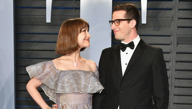 Andy and Joanna smiling at each other on a red carpet