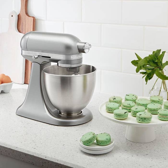 A stand mixer beside a tray of macarons