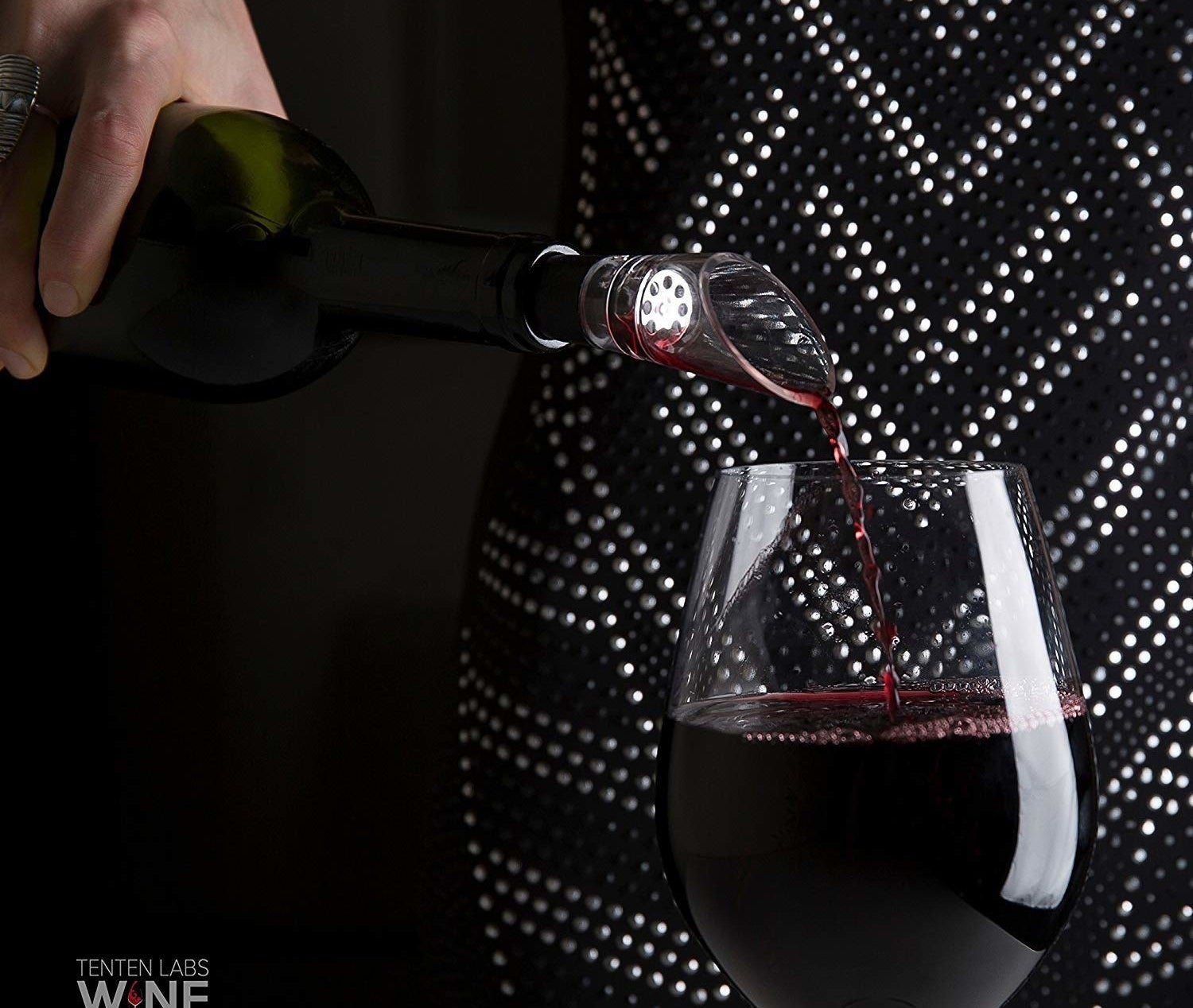 Someone pouring wine using the decanter. 