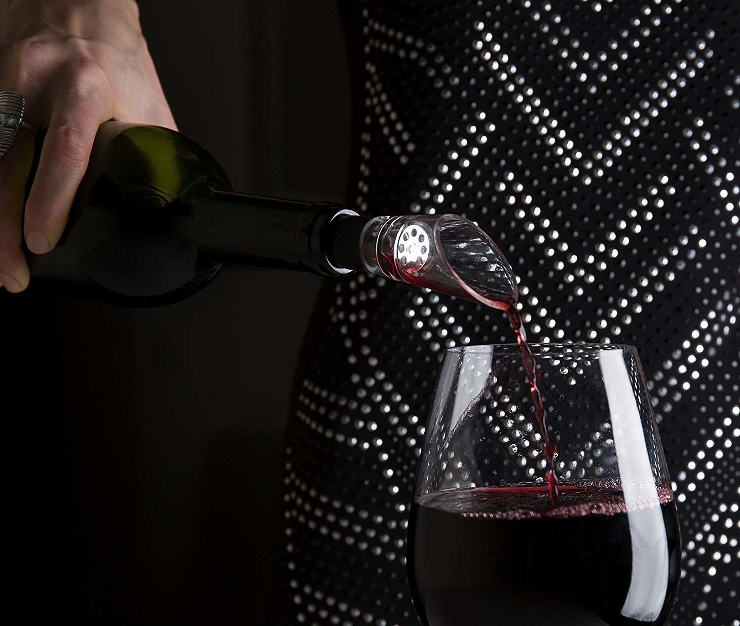 Someone pouring wine using the decanter. 