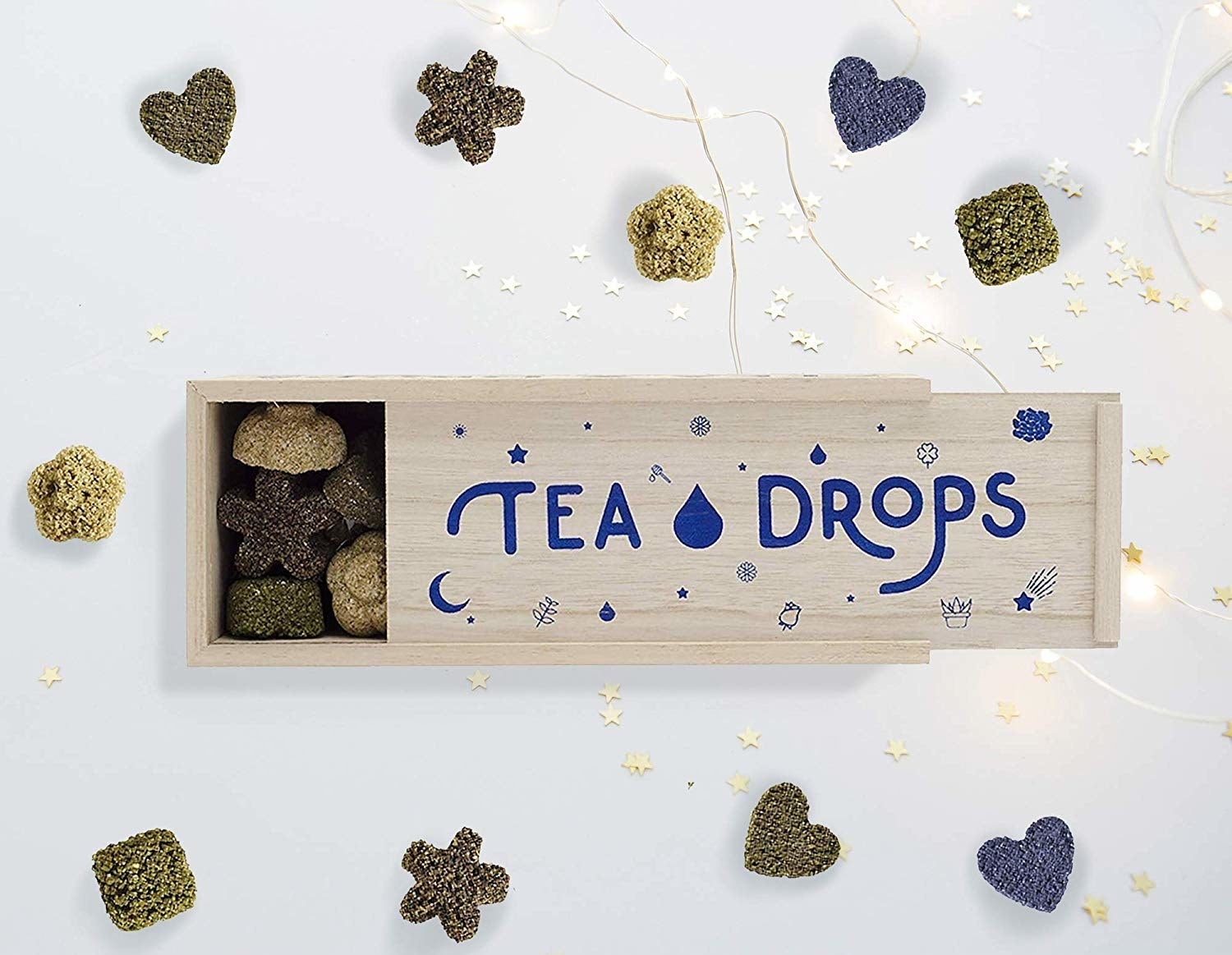 wooden box filled with pressed tea shaped like stars, flowers, and hearts 