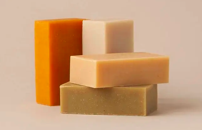 A stack of four different-colored shampoo soap bars 