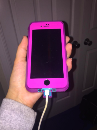 reviewer holding phone with a pink case on it