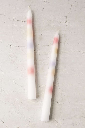 Two white candlesticks with dots of inner colored wax