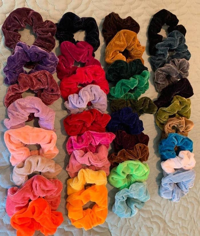 reviewer&#x27;s assortment of colorful velvet scrunchies 