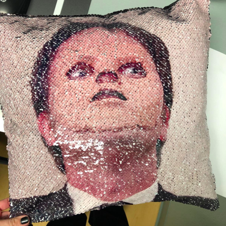 A customer review photo of the pillow showing the design of Dwight from The Office wearing the fake skin mask.