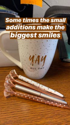 the metallic, polka dot pens with fake diamond on top in front of a coffee mug on a desk