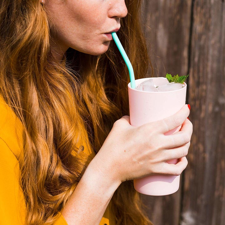person using straw to sip a smoothie