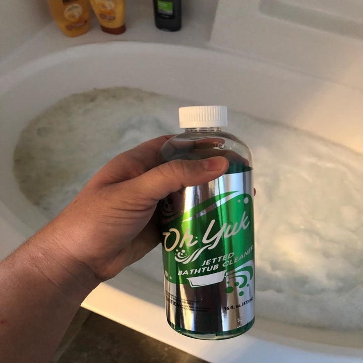 reviewer holding the bottle of cleaner 