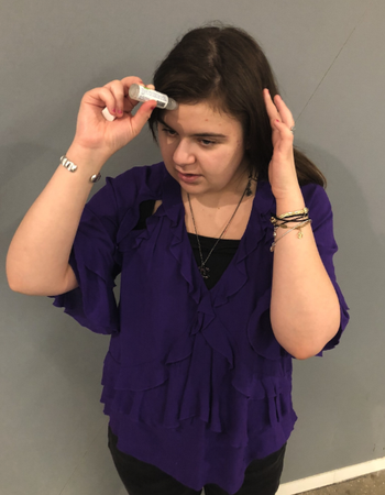 buzzfeed writer applying the migraine stick to her forehead