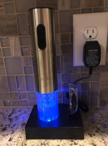 reviewer image of the rechargeable secura electric wine opener charging on a kitchen counter