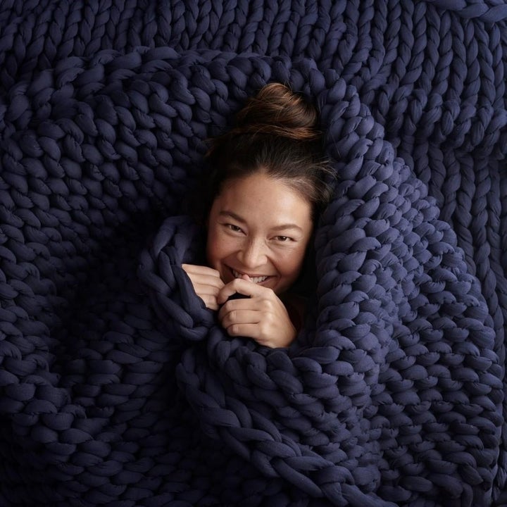 a model surrounded by the blanket in dark blue