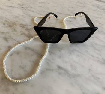 BuzzFeed editor pearl chain attached to black sunglasses